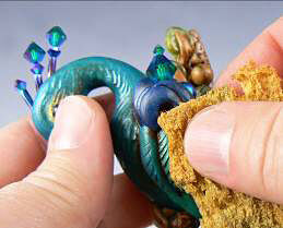 Clay peacock being dabbed with a sponge